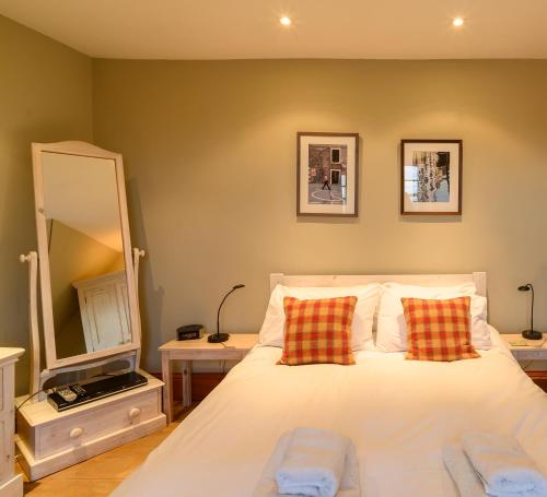 um quarto com uma cama com duas almofadas e um espelho em Crail Posthouse - 19th Century traditional house em Crail