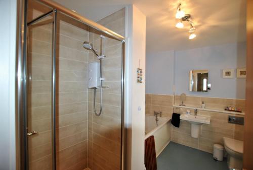 uma casa de banho com um chuveiro e um lavatório. em The Neuk- contemporary coastal apartment em Anstruther
