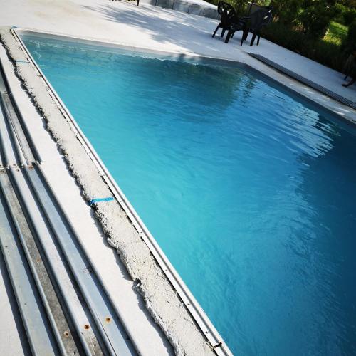 - une vue sur la piscine d'eau bleue dans l'établissement Chez Sandrine - Chambres avec pension ou demi pension, à Gray-la-Ville