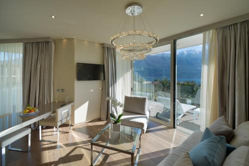 ein Wohnzimmer mit einem Tisch und einem Kronleuchter in der Unterkunft Park Hotel Imperial in Limone sul Garda