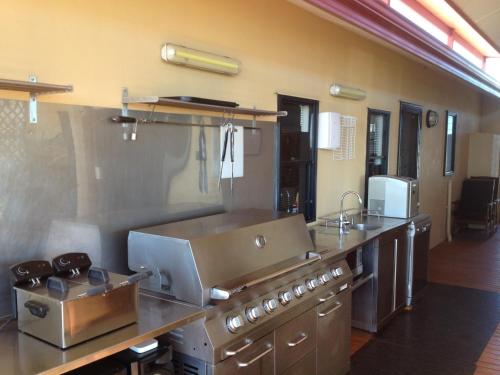 a large kitchen with a stove and a sink at On the Deck @ Shark Bay in Denham