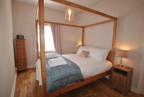 a bedroom with a four poster bed and a window at Seaspray- harbourfront home in idyllic location in Pittenweem