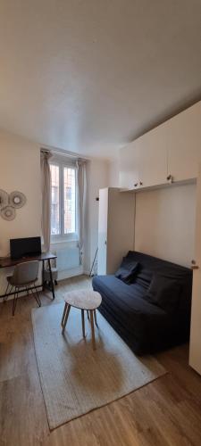 a bedroom with a bed and a table and a desk at Studio en RDC - Quai de Garonne - Capitole - Wifi in Toulouse