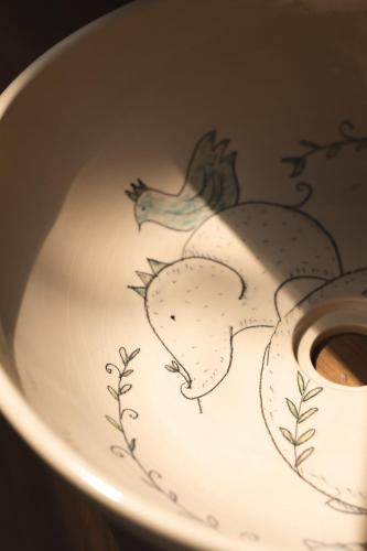 a white bowl with a drawing of a rooster on it at Proud Phu Fah Muang Chiang Mai in Chiang Mai