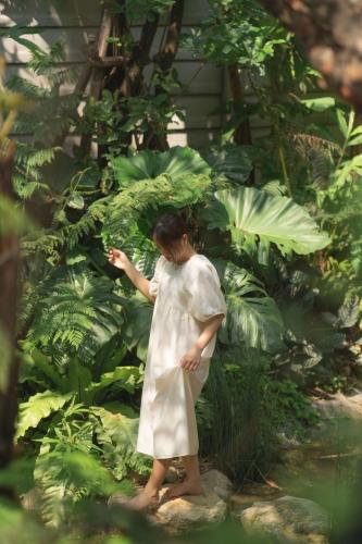 a woman in a white dress standing in a garden at Proud Phu Fah Muang Chiang Mai in Chiang Mai