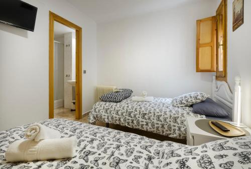 a room with two beds and a sink in it at Casa Campanilla Jaca in Jaca