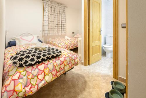 a bedroom with two beds and a toilet at Casa Campanilla Jaca in Jaca