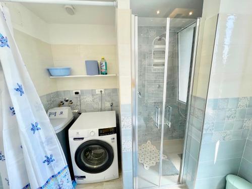 a bathroom with a washing machine and a shower at Trilocale Jolly in Marina di Bibbona