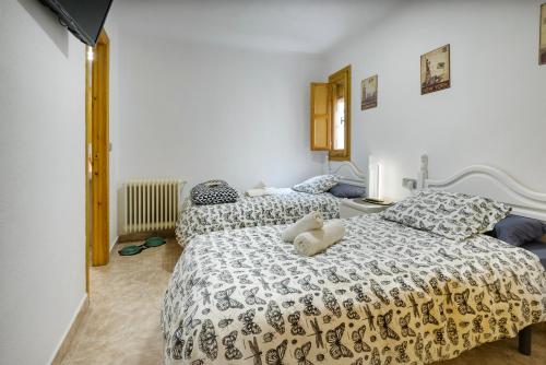 Dos camas con animales de peluche en un dormitorio en Casa Campanilla Jaca en Jaca