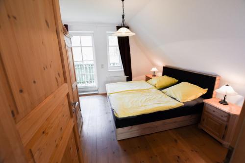 a bedroom with a bed with yellow sheets and a window at Dorfstr_ OT Mueggenburg in Klein Kirr