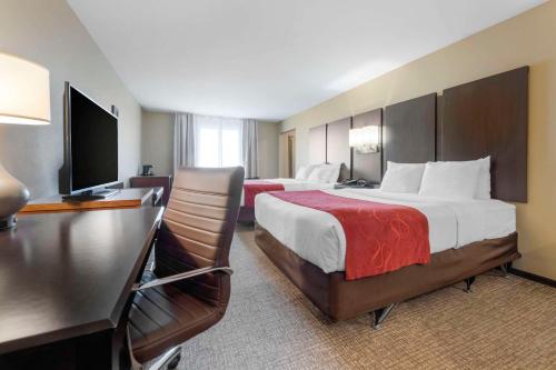 Una habitación de hotel con dos camas y un escritorio. en Comfort Suites & Conference Center, en Worthington