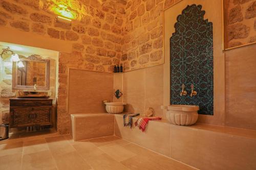 a bathroom with a tub and a sink in a room at Ankahan Konağı in Mardin