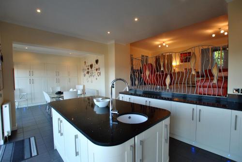 Una cocina con encimera negra y fregadero. en Anchor House Pittenweem - Seaview home, en Pittenweem