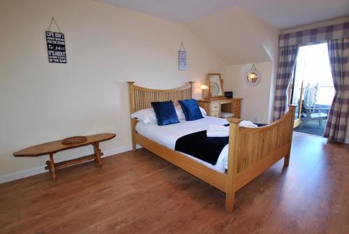 a bedroom with a bed with blue pillows and a table at Anchor House Pittenweem - luxurious 4 bedroom in Pittenweem