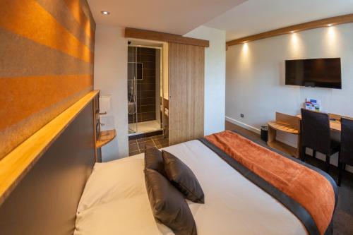 une chambre d'hôtel avec un lit et une table dans l'établissement Hôtel Foch, à Tarbes