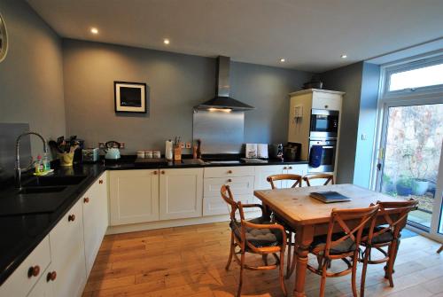 a kitchen with a wooden table and a table and chairs at 2 Melville Terrace Anstruther in Anstruther