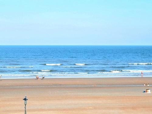 a beach with people walking on the sand and the ocean at Direct Oceanfront With Balcony in Daytona Beach