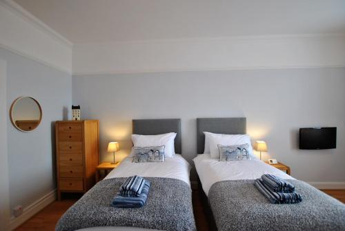 two twin beds in a room with a tv at Gyles Apartment - harbourfront studio Pittenweem in Pittenweem
