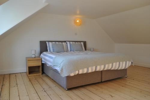 a bedroom with a large bed with a light on it at Craws Nest Cottage- stylish traditional home in Pittenweem