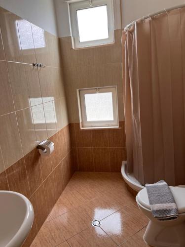 a bathroom with a shower and a toilet and a sink at Hotel Bella vista in Orikum
