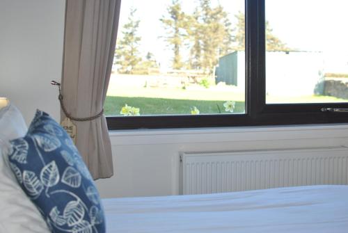 a bedroom with a window and a bed with a pillow at Kittle View near Anstruther in Carnbee