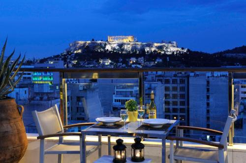 una mesa y sillas en un balcón con vistas en Dorian Inn - Sure Hotel Collection by Best Western, en Atenas