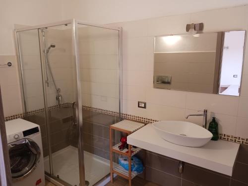 a bathroom with a sink and a glass shower at Le Porte del Sole in Girasole