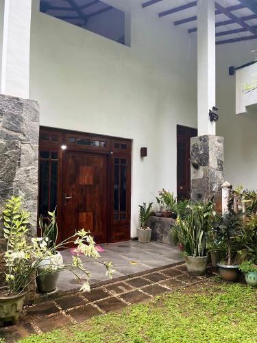 a front door of a house with potted plants at Rustic Mahaweli in Kandy