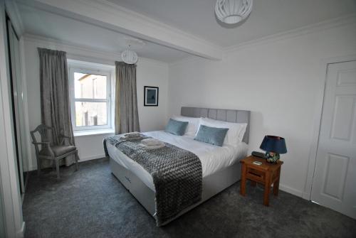 a bedroom with a large bed and a window at Mariners Retreat- spacious apartment in Crail in Crail