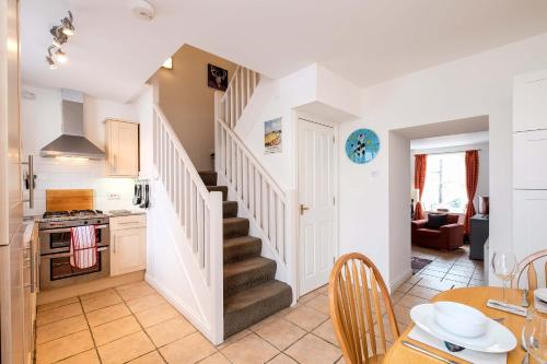 a kitchen and dining room with a staircase in a house at Sea Whisper- lovely home in charming village in Pittenweem
