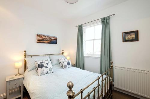 a bedroom with a bed and a window at Sea Whisper- lovely home in charming village in Pittenweem