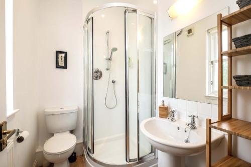 a bathroom with a shower and a toilet and a sink at Sea Whisper- lovely home in charming village in Pittenweem