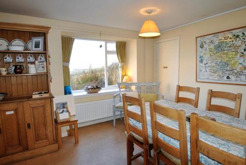 a dining room with a table and chairs and a window at Catherine Cottage seaside home in Anstruther