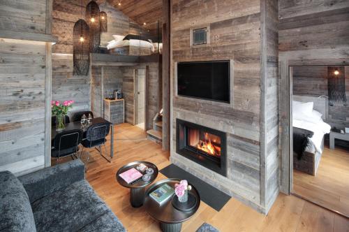ein Wohnzimmer mit einem Kamin und ein Schlafzimmer in der Unterkunft Hostellerie du Pas de l'Ours "Relais et Châteaux" in Crans-Montana