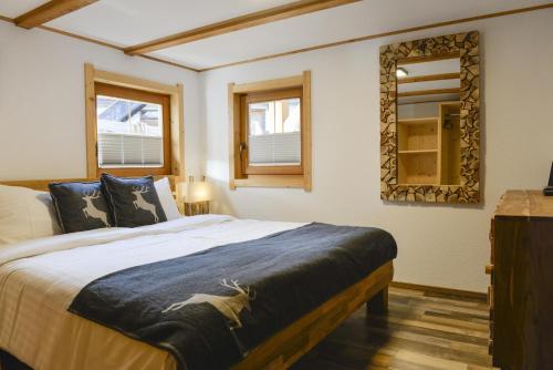 a bedroom with a large bed and a mirror at Ferienwohnung Kast'l in Alpbach
