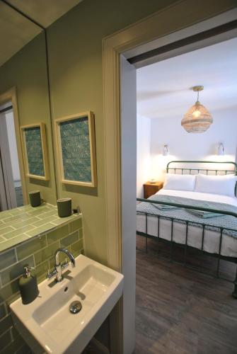 a bathroom with a sink and a bed with a mirror at Puffin House- stylish home by the sea in Anstruther