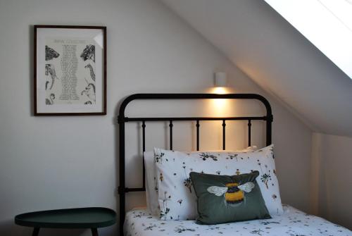 een slaapkamer met een bed met een kussen en een lamp bij Puffin House- stylish home by the sea in Anstruther