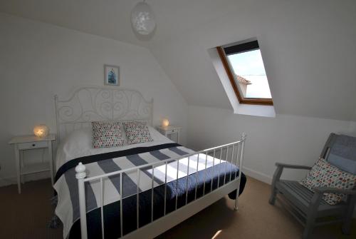 a bedroom with a bed and a chair and a window at Seaglass Cottage-family friendly home in East Neuk in Pittenweem