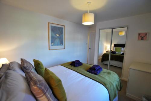 Un dormitorio con una cama con almohadas azules. en Calabeinn, en Anstruther