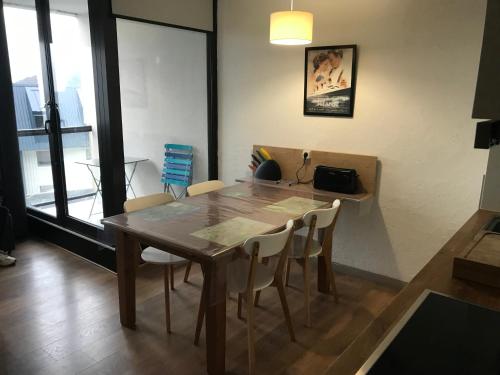 une salle à manger avec une table et des chaises en bois dans l'établissement Appartement les Myrtilles à Super Besse au pied des pistes, à Super-Besse