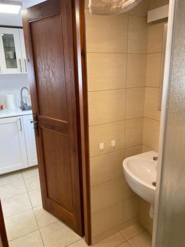a bathroom with a wooden door and a sink at Pokoje Kochanowskiego in Sopot