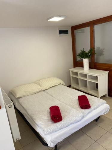 um quarto com uma cama com duas toalhas vermelhas em Pokoje Kochanowskiego em Sopot
