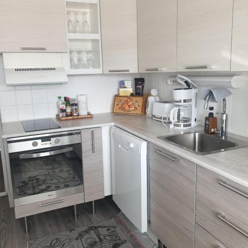 a kitchen with a sink and a stove top oven at Rauhallinen kaksio keskustassa in Imatra