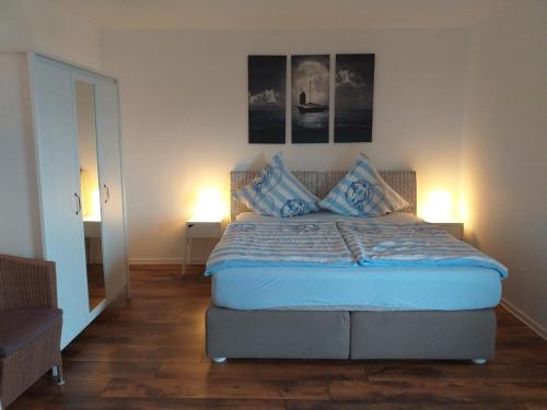 una camera da letto con letto con lenzuola e cuscini blu di Ferienwohnung 211 a Timmendorfer Strand
