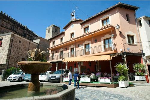 a building with a fountain in front of a building at Casa rural Aloha Vera in Jarandilla de la Vera