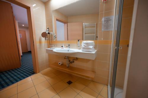 a bathroom with a sink and a shower at Wellness Hotel Montis in Mozirje