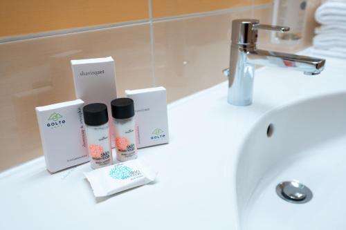 a bathroom sink with some products on a counter at Wellness Hotel Montis in Mozirje