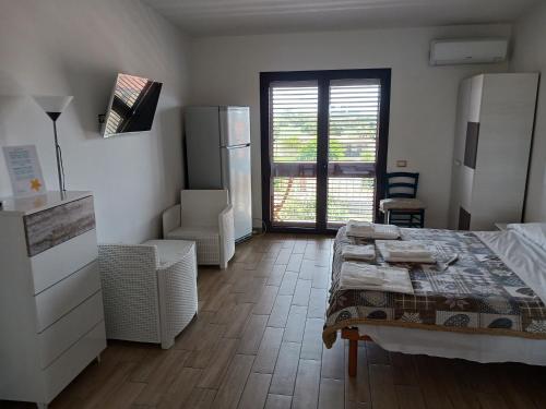 Habitación con 1 dormitorio con 1 cama y nevera. en Le Porte del Sole, en Girasole