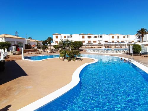 a large swimming pool next to a resort at Villa Sabina in San Miguel de Abona