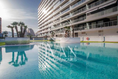 ein Schwimmbad vor einem großen Gebäude in der Unterkunft Casa Paraíso Ivan Luxury Homes 6ªPlta Sur 1ªLinea in Oropesa del Mar